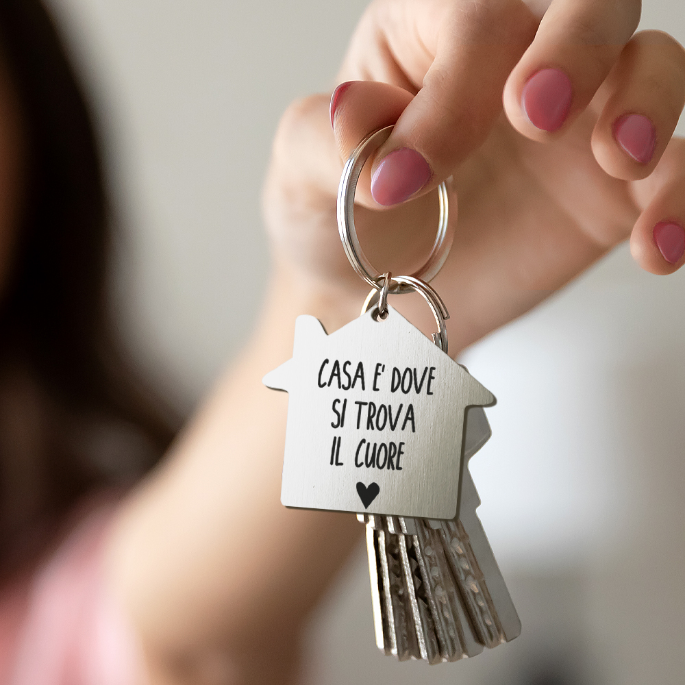 portachiavi di casa in legno su recinzione con chiave e iscrizione in  lettere inglesi home. casolare sullo sfondo. costruzione, progetto,  trasloco in nuova casa, mutuo, affitto e acquisto di immobili. 7065650 Stock